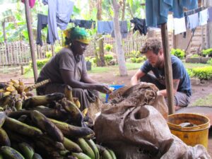 Roberto e Mama Gimi sbucciano le banane per preparare l'mbege a Kasirwa, Tanzania, 2015